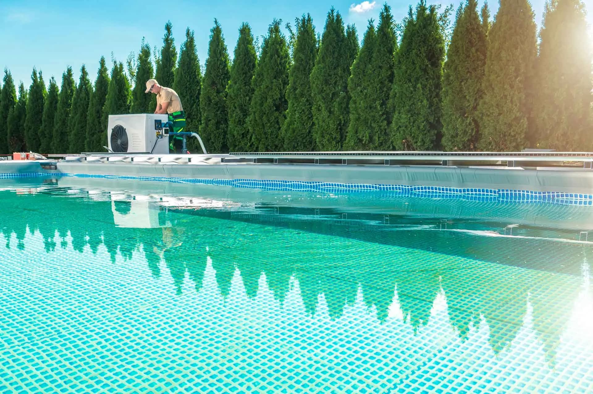 Técnico revisando una bomba de calor instalada junto a una piscina