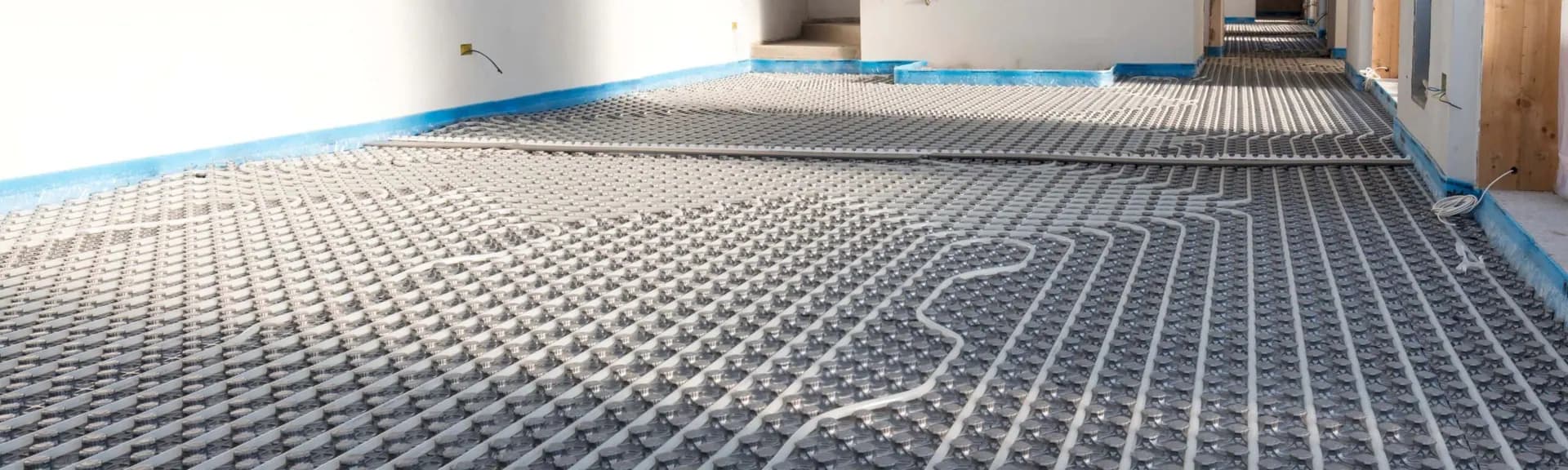 Instalación de suelo radiante con tubería sobre panel aislante en obra