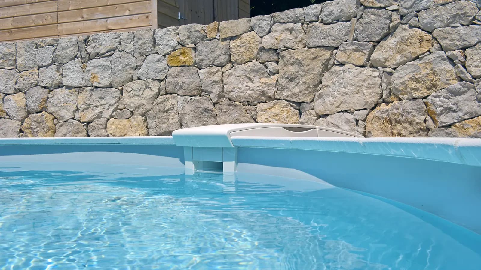 Detalle del sistema de filtración y skimmer en el borde de una piscina